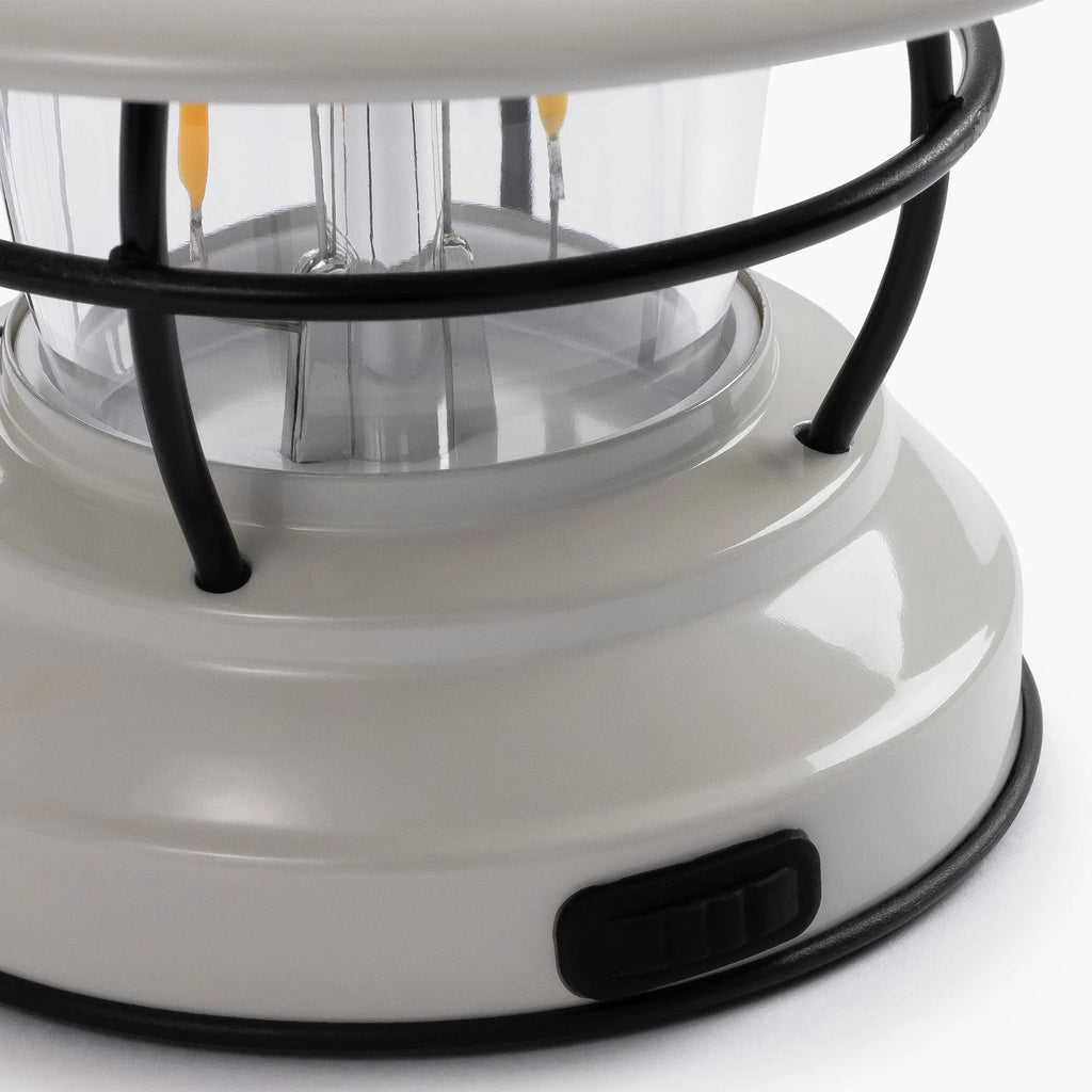 Close up of USB port on White mini Edison lantern by Barebones brand with vintage style and caged bulb on a white background