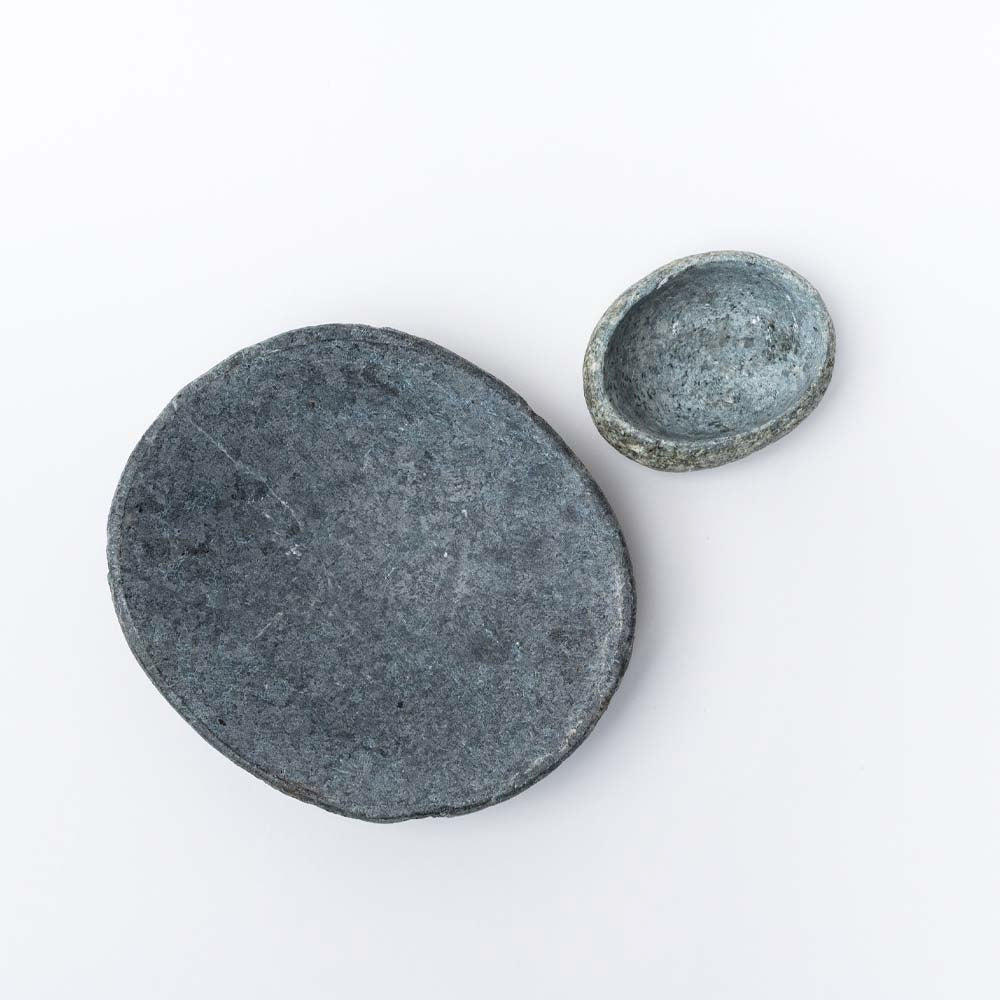 Large and small stone bowls photographed from above on a  white background