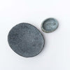 Large and small stone bowls photographed from above on a  white background