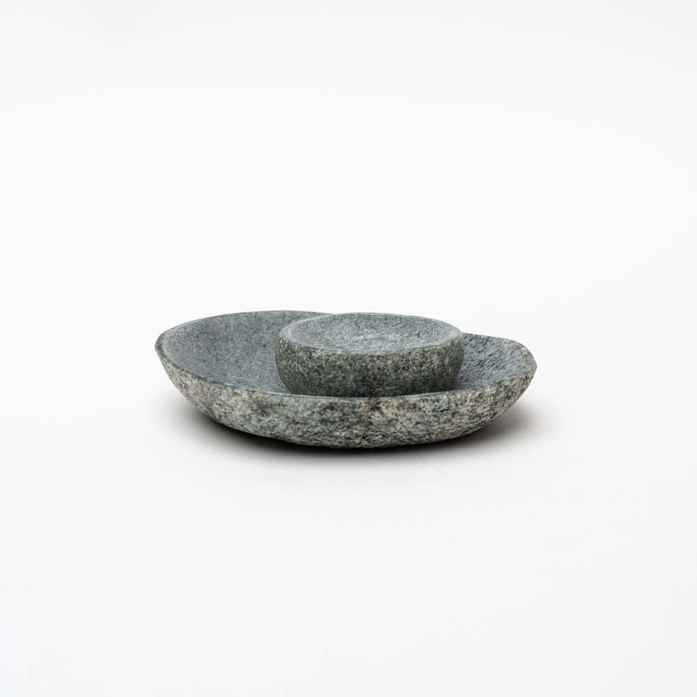Large and small stone bowls stacked on a white background