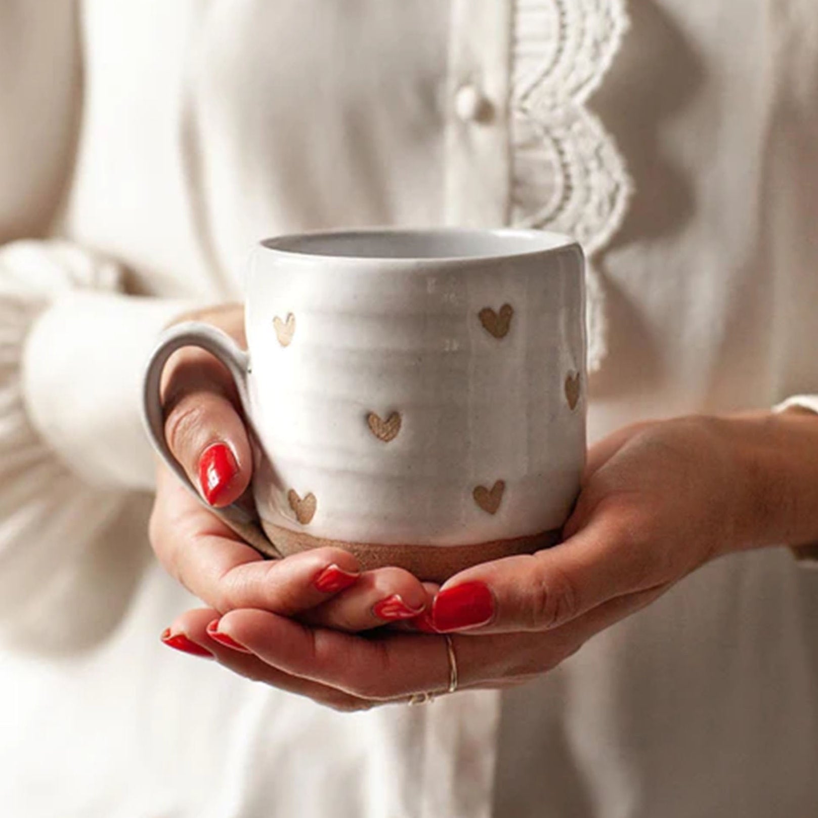 Farmhouse Pottery brand confetti heart mug being held by a model with red nails 