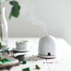Farmhouse Pottery Beehive Burner lit on a table with matches nearby
