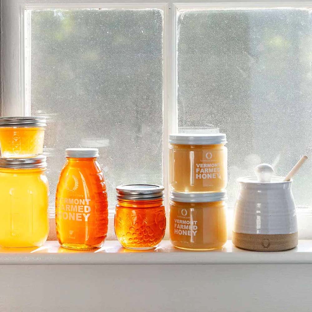 Farmhouse Pottery Beehive Honey Pot on a shelf with honey 