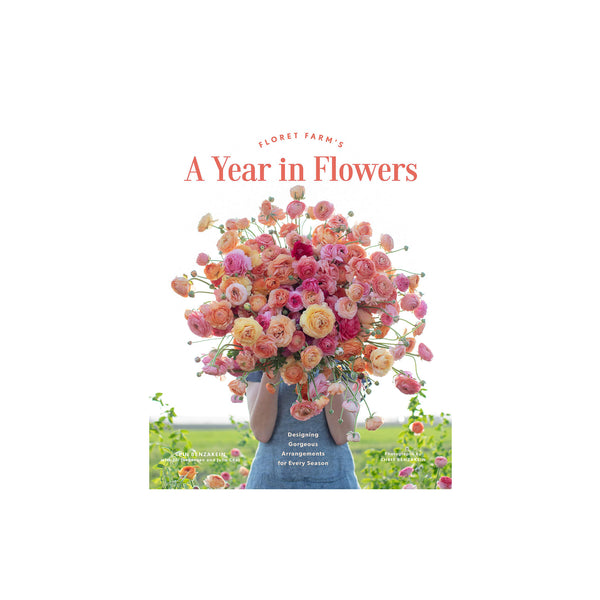 Cover of book titled 'Floret Farm's a Year in Flowers' with women holding large bouquet of pink and orange flowers in a white background 
