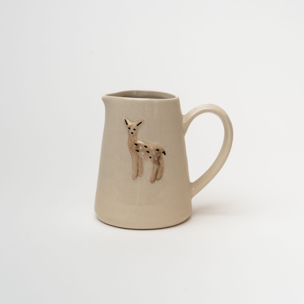Small pitcher with deer stamped on front on a white background