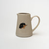 Small pitcher with porcupine stamped on front on a white background