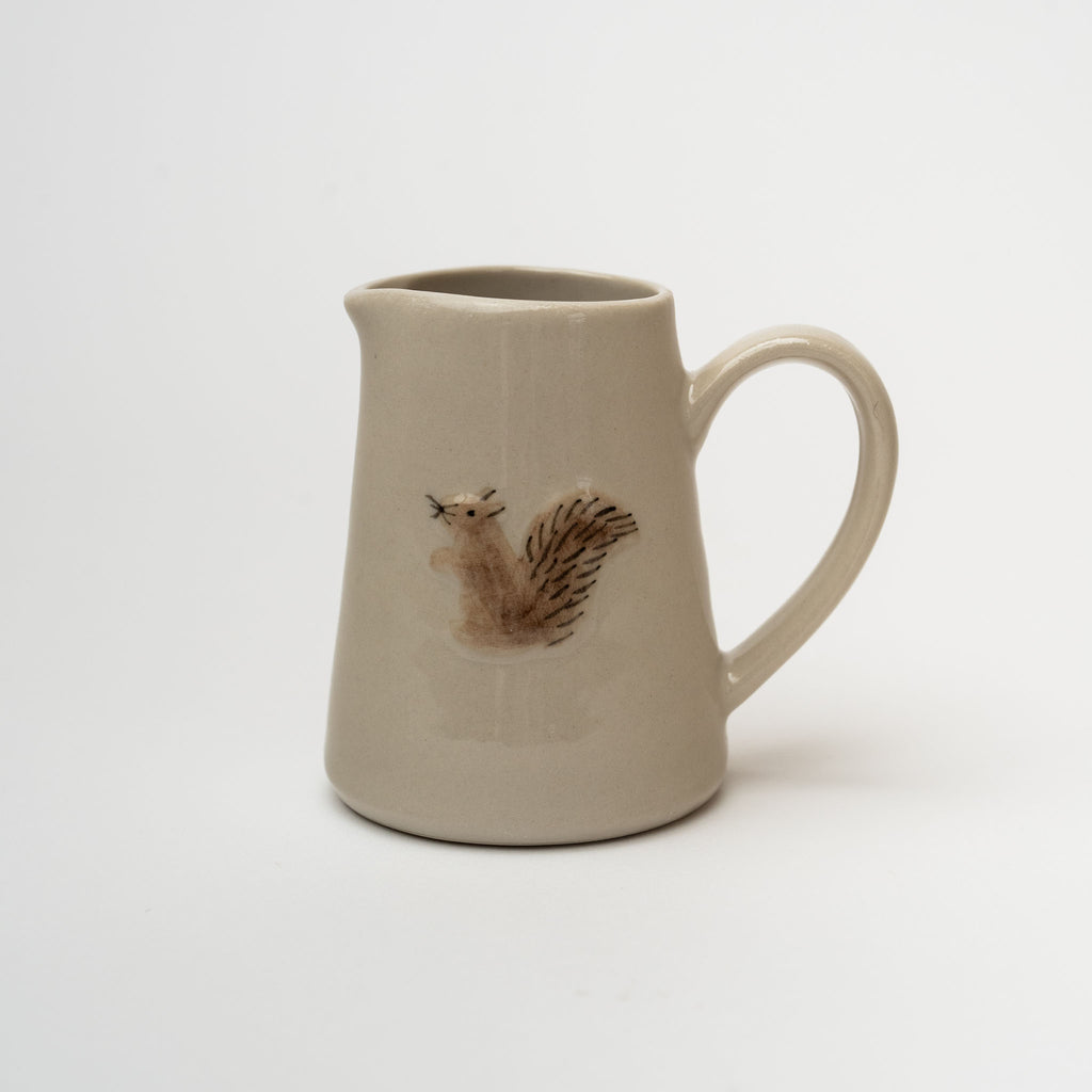 Small pitcher with squirrel painted on front on a white background