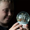 Boy looking at snow globe with fox and bear 