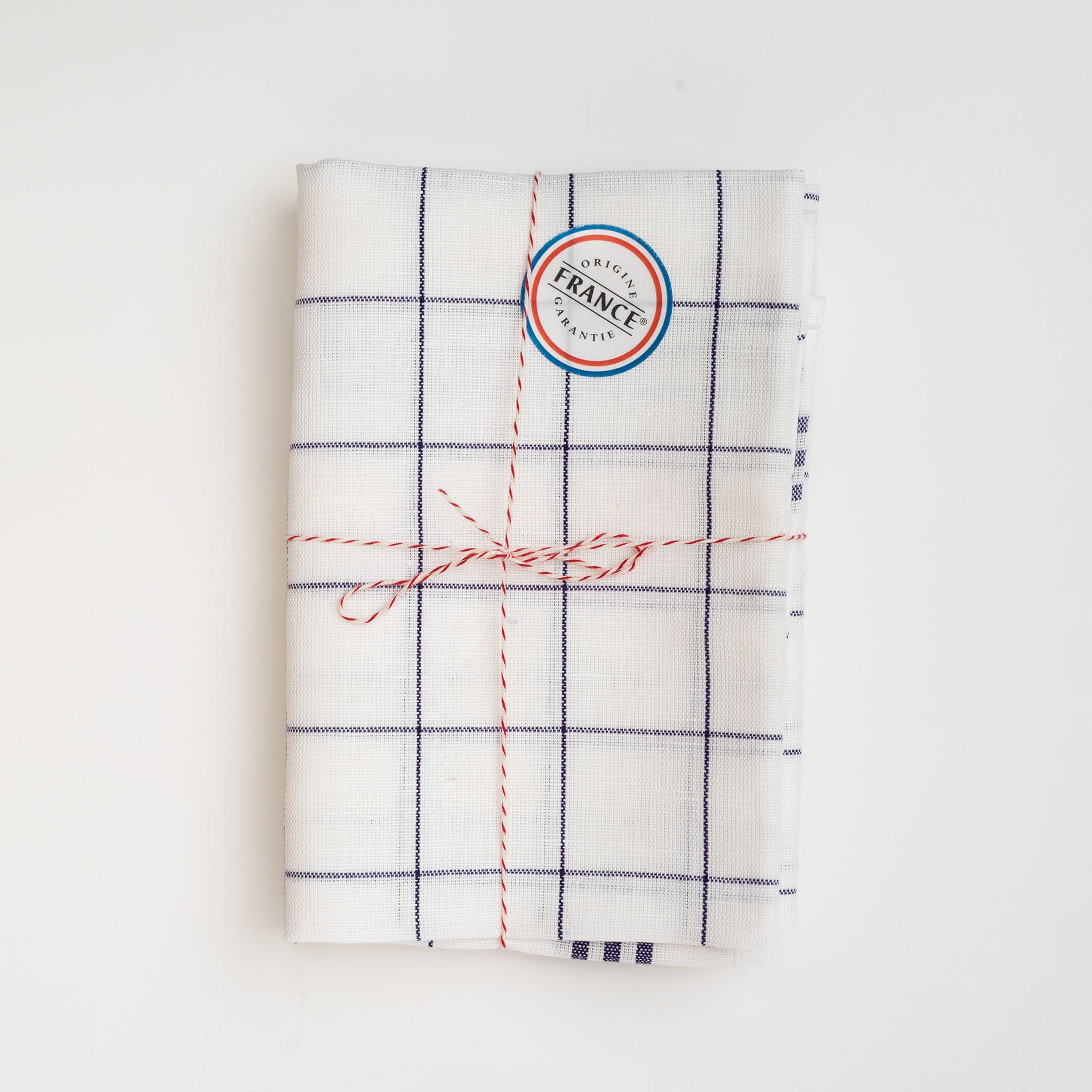Set of two blue plaid Tissage de L’Ouest tea towels with made in France sticker on a white background