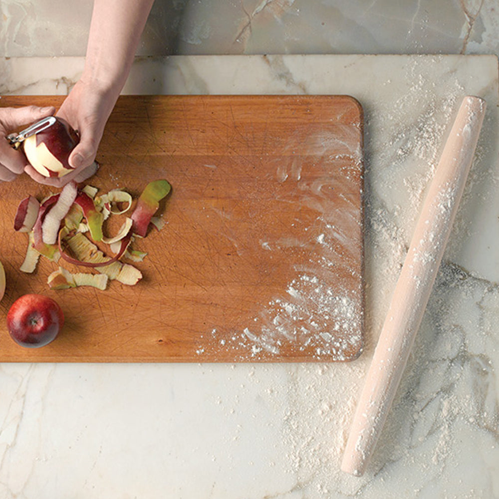 JK Adams French tapered rolling pin on a marble surface with hands peeling apples