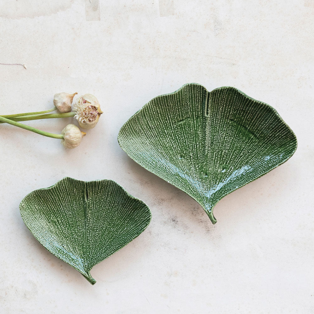 Large and small Ginko leaf plate on a white surface 