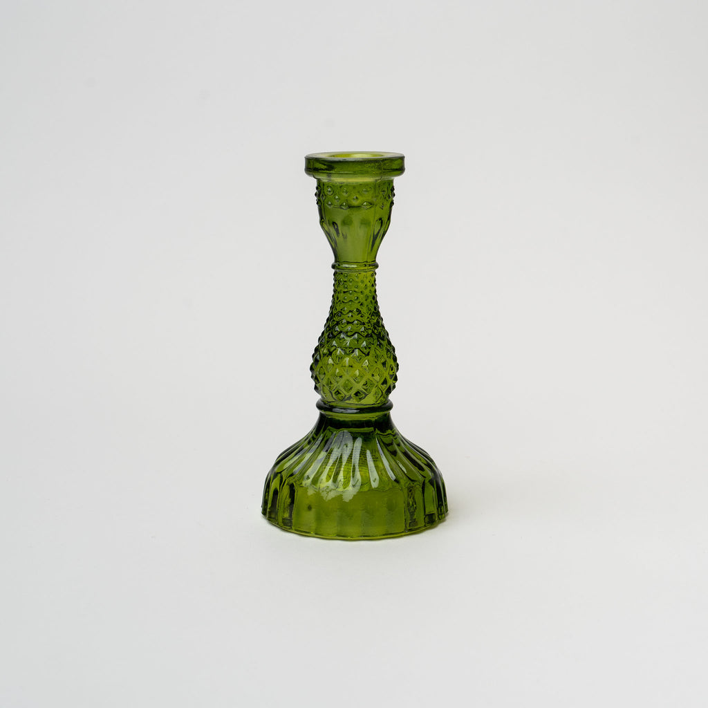 Green pressed glass candle stick on a white background