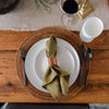 Black stainless flatware set at a place setting with rattan placemat