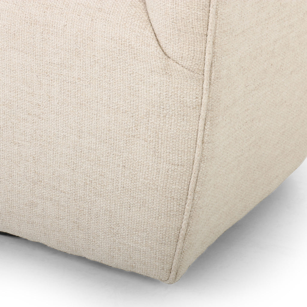 Close up of Barrel style 'Hanover' swivel chair upholstered in cream fabric by Four Hands furniture on a white background 