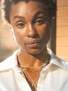 Scream pretty brand gold headphones necklace on a model with white shirt 