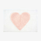 White bathmat with pink heart on a white background
