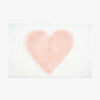 White bathmat with pink heart on a white background