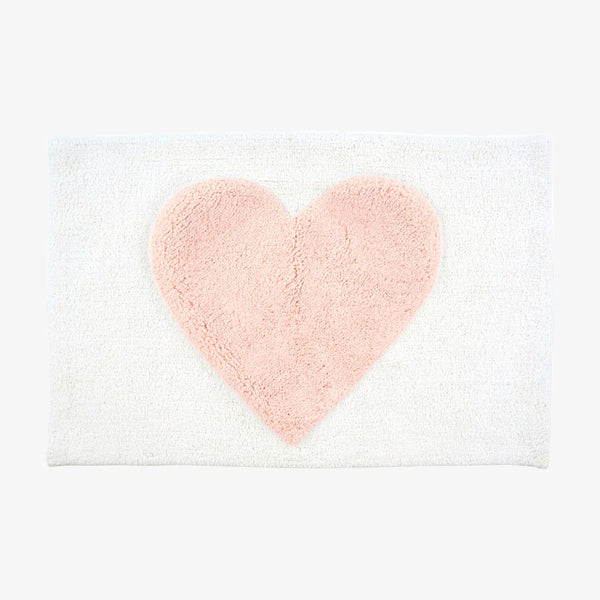 White bathmat with pink heart on a white background