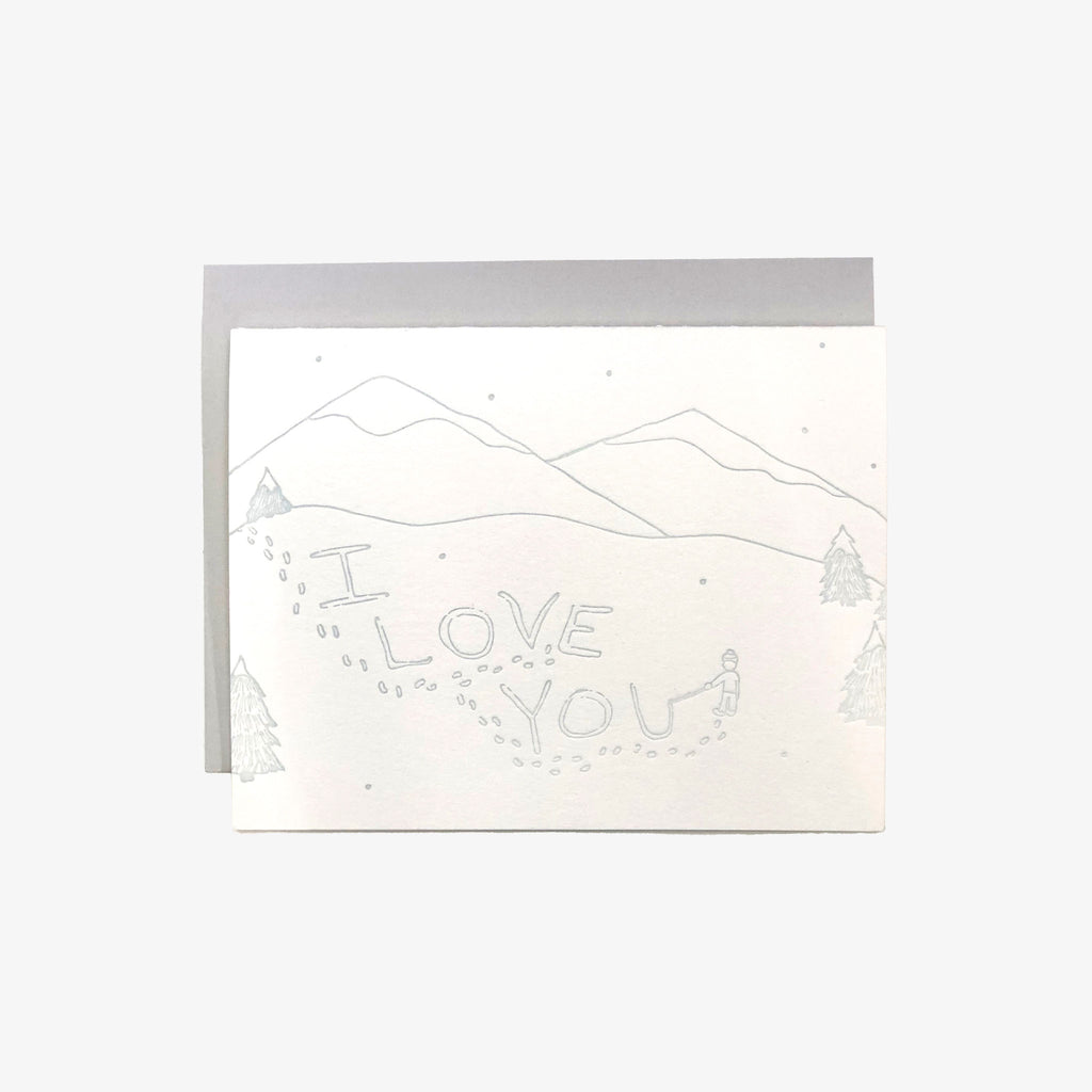 Letterpress greeting card with i love you written in snow on a white card