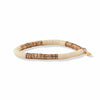 Ink and alloy brand ivory and gold stretch bracelet on a white background