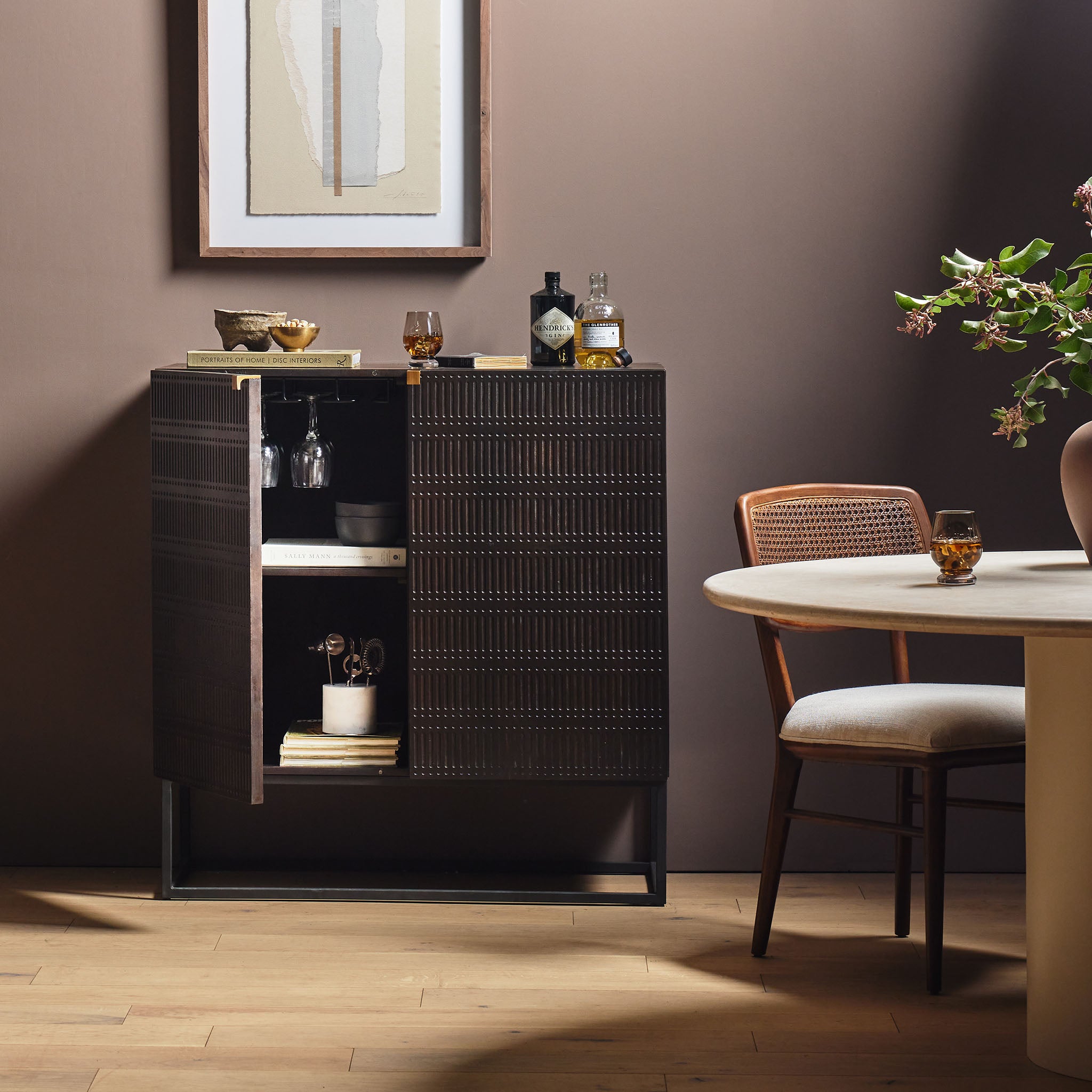 Kelby brown wood bar cabinet with carved doors and black iron frame base by four hands furniture win a dinning room area with barware