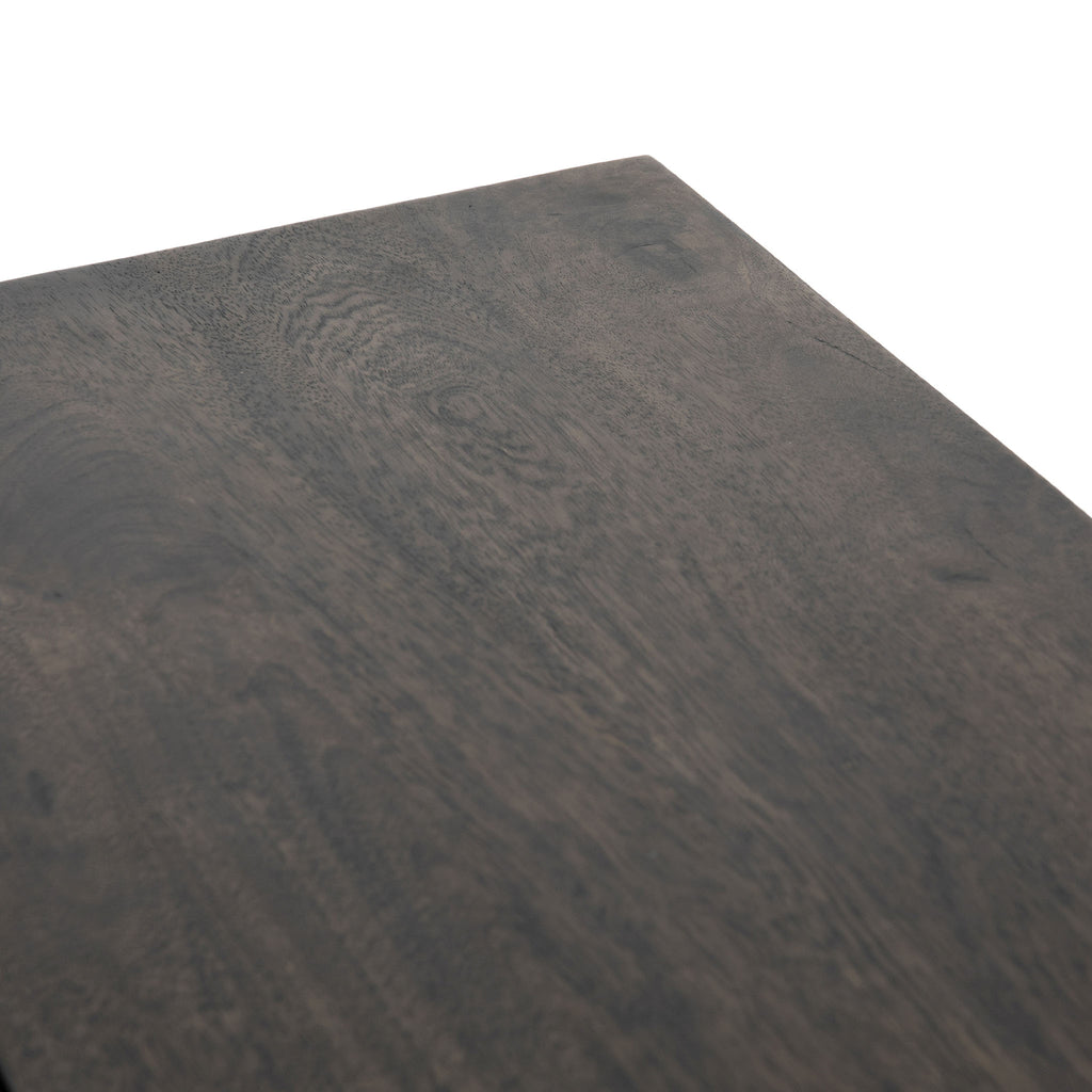Close up of wood surface on Four hands furniture brand Kelby media console with iron base and four carved doors with square brass pulls on a white background