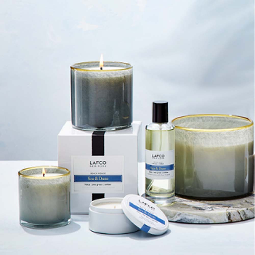 Lafco brand 'sea and dune' candles and accessories on a blue background