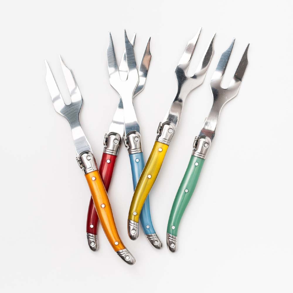 Laguiole rainbow colored cheese forks on a white background
