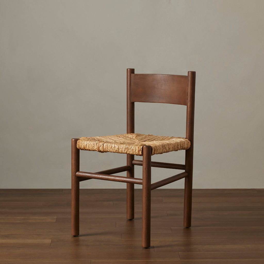 Close up of rush seat on wood 'Largo' dining chair in russet mango by four hands furniture in room with wood floor and grey walls
