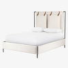 Upholstered 'Leigh' bed by Four hands furniture with metal frame and buckled head board panels on a white background