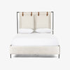 Upholstered 'Leigh' bed by Four hands furniture with metal frame and buckled head board panels on a white background