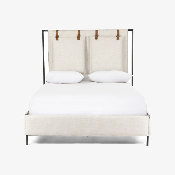 Upholstered 'Leigh' bed by Four hands furniture with metal frame and buckled head board panels on a white background