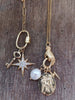 Scream Pretty brand gold lightening bolt charm on a necklace with multiple other charms