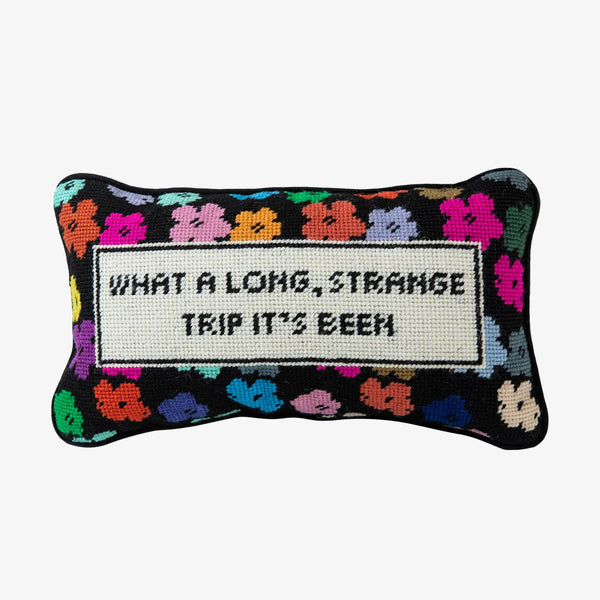 Needlepoint pillow by Furbish brand with bright colors and phrase 'what a long strange trip its been' on a white background