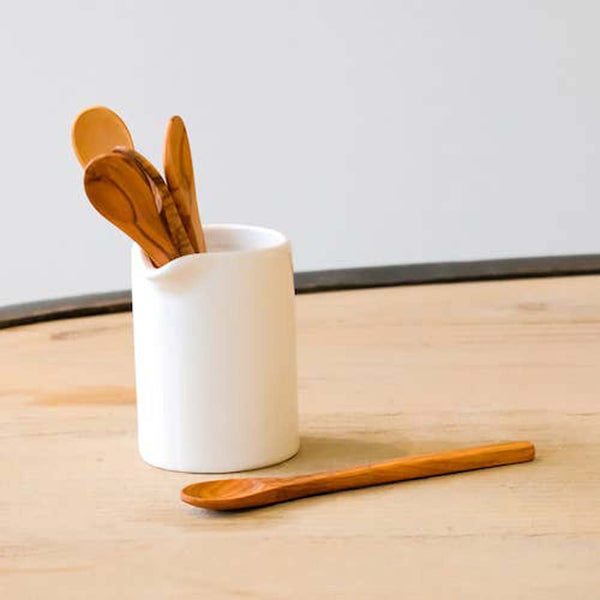  Solid olivewood jam spoon inside a white ceramic pitcher 