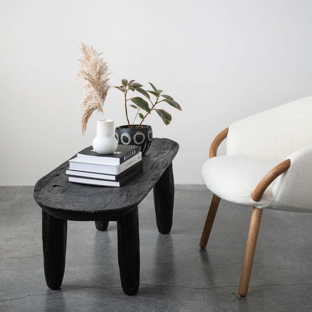 Creative Coop marble vase with round base and ridged straight neck on a coffee table with books and other decorative items