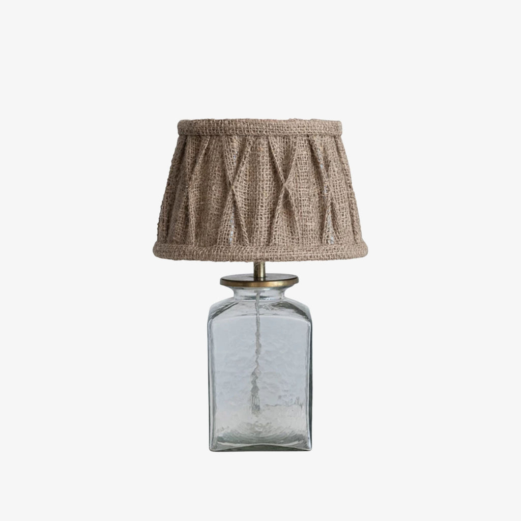 Small glass table lamp with burlap shade on a white background