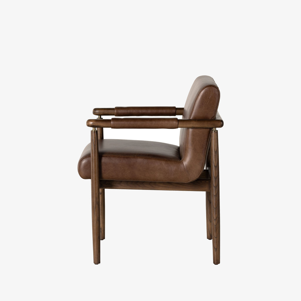 Brown leather 'Markia' arm dining chair with wood frame by four hands furniture on a white background