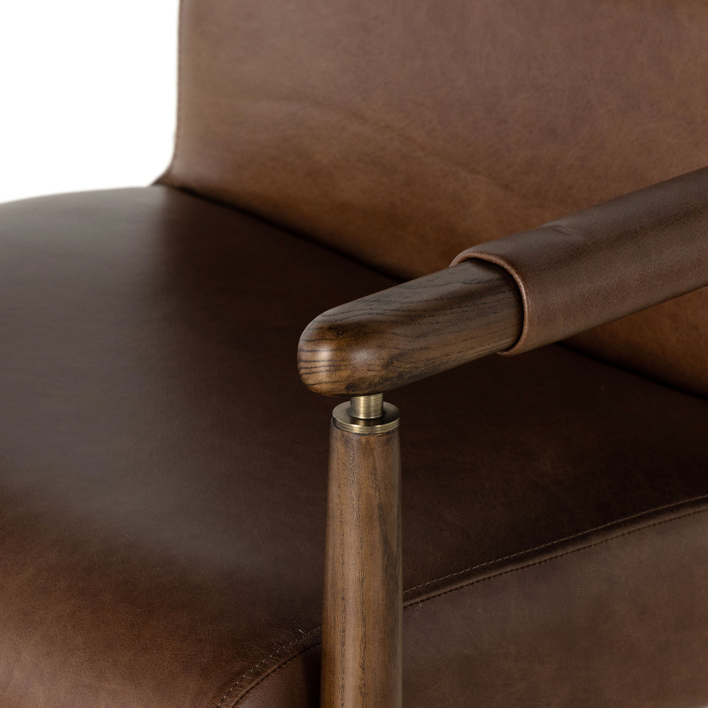 Close up of Brown leather 'Markia' arm dining chair with wood frame by four hands furniture on a white background