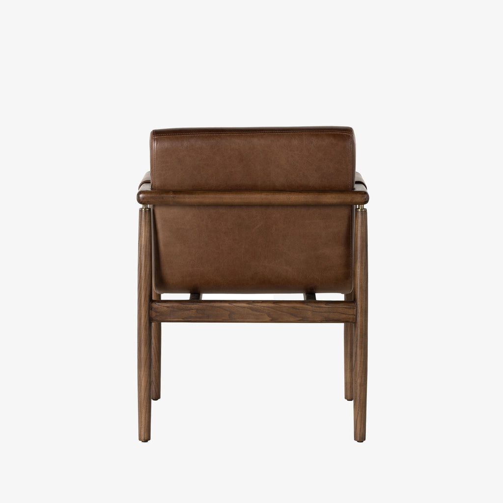 Brown leather 'Markia' arm dining chair with wood frame by four hands furniture on a white background