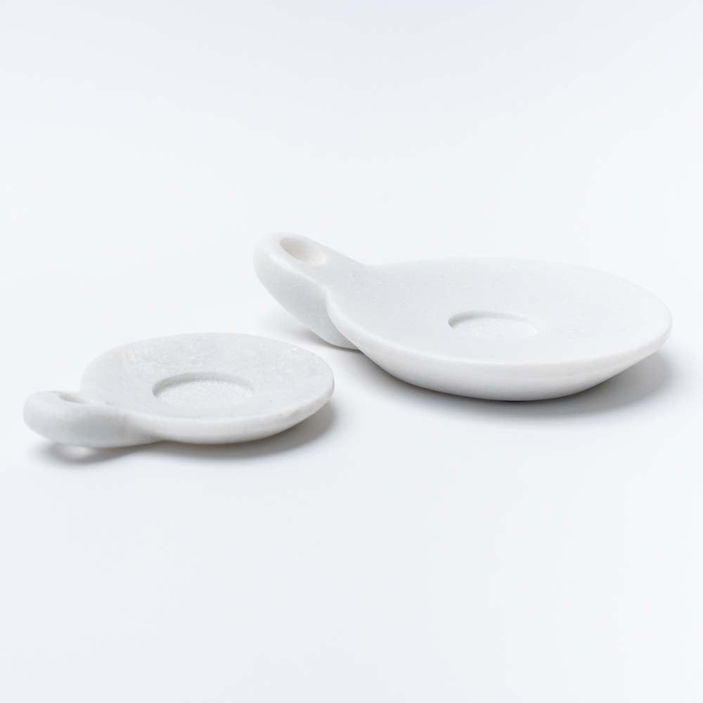 Two marble dishes with handles on a white background