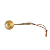Brass finish metal scoop with leather tie on a white background