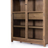 Four hands furniture brand Millie oak cabinet with glass doors and four shelves and interior drawer on a white background