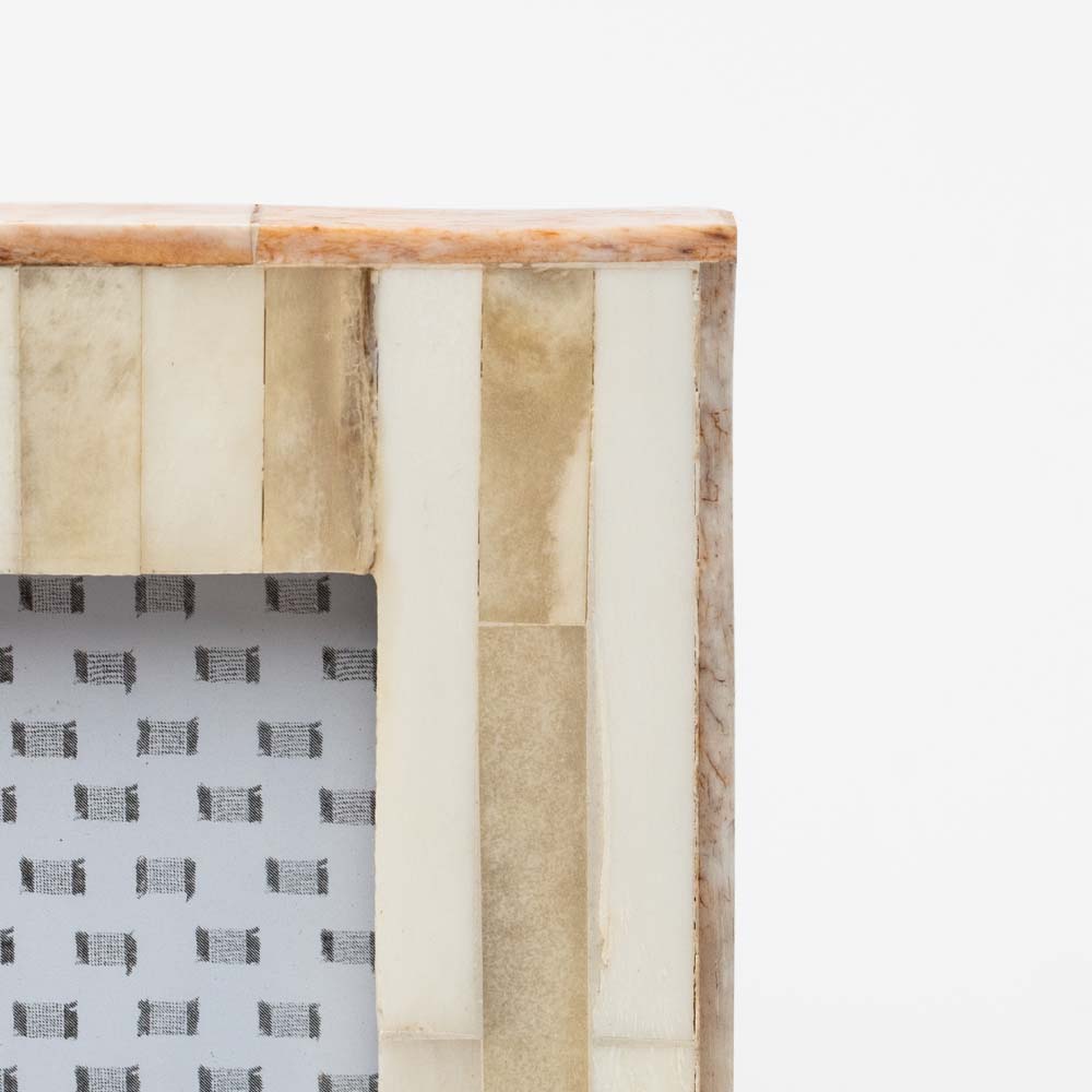 Close up of Small white and wood picture frame on a white background