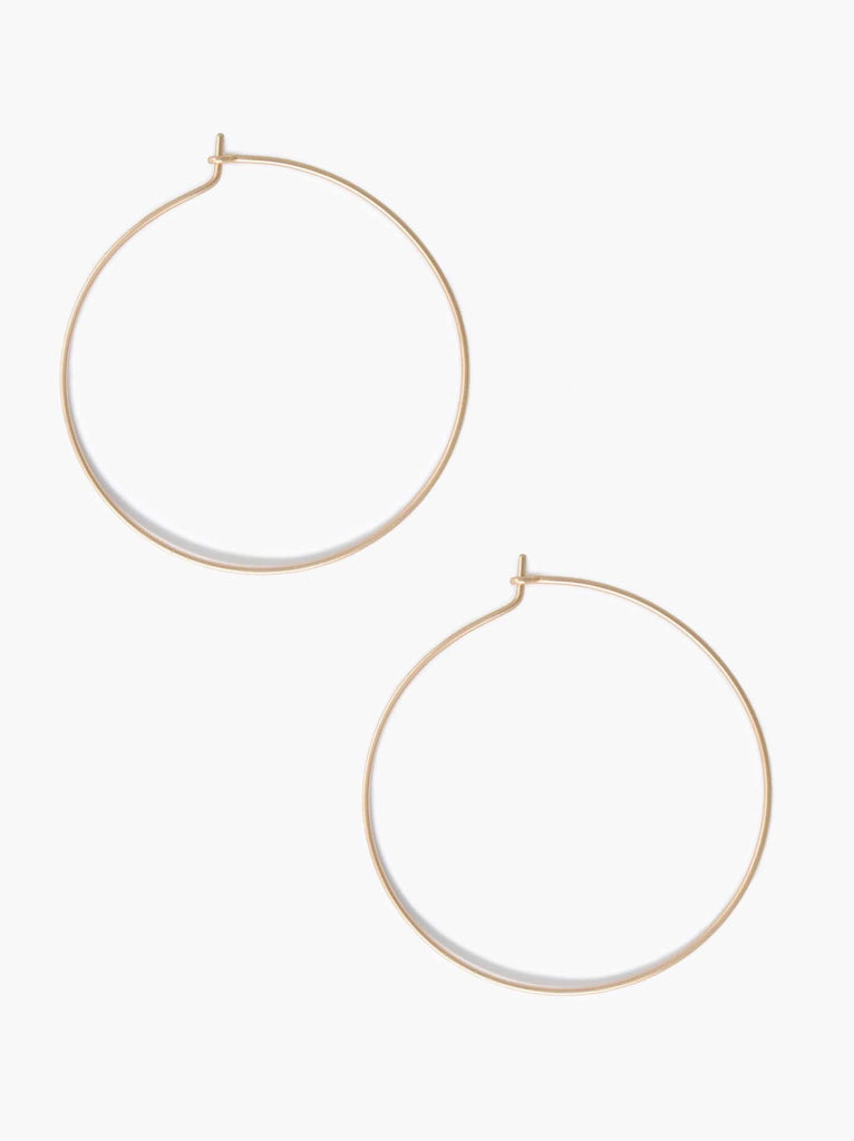 Able brand Minka thin hoop earrings in 14 carat gold fill on a white background