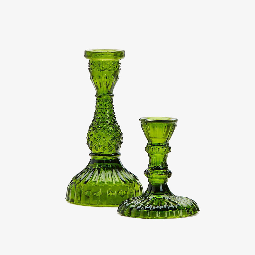 Set of green cut glass candle sticks on a white background