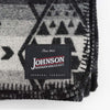Close up of Johnson Woolen Mills wool blanket in charcoal grey aztec print on a white background  