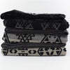 Stack of 3 Johnson Woolen Mills wool blanket in charcoal grey aztec print on a white background  