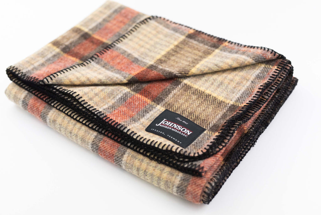 Close up of Johnson Woolen Mills wool blanket in brown, black and beige check print on a white background