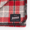 Close up of Johnson Woolen Mills wool blanket in grey and red check print on a white background